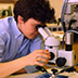 Conservator examining a photographic print using a binocular microscope.