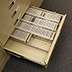 Proper storage of cassette tapes: upright and supported to prevent sliding and tipping in the drawer.