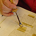 Pressure-sensitive tapes can both stain and chemically damage paper. They can be removed using heat, as shown here, or with organic solvents, or a combination of the two.